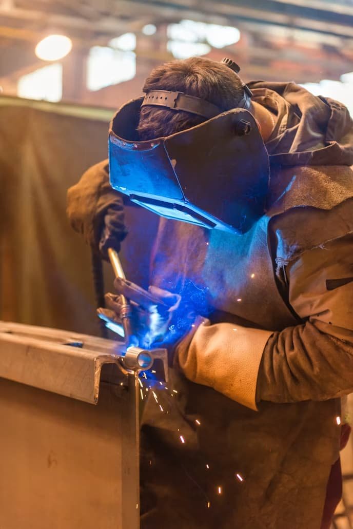 CF3 technician performing structural MIG welding on a vehicle at the Cardiff garage in Rumney