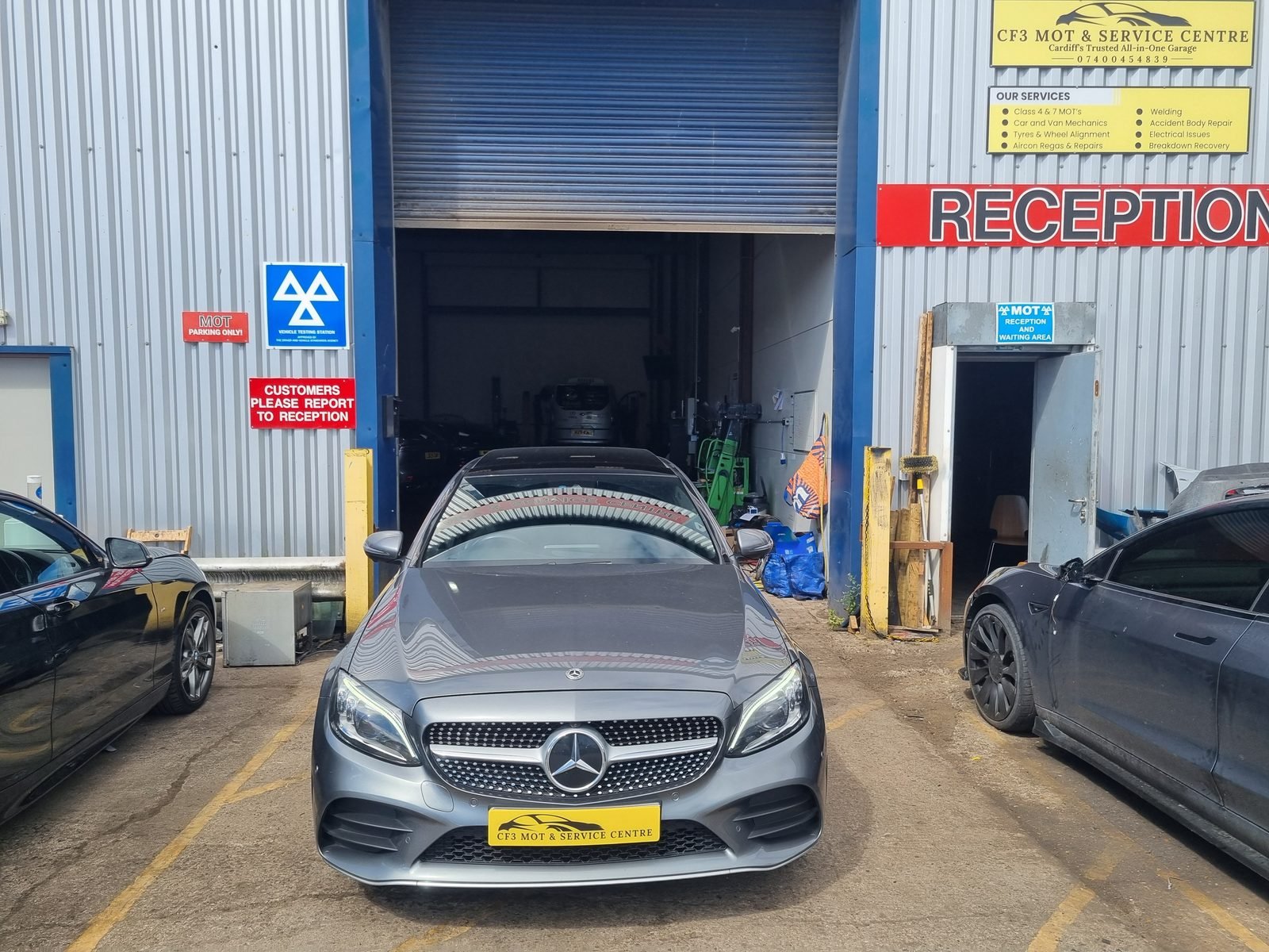 CF3 MOT and Service Centre workshop entrance on Wentloog Road in Rumney with the roller shutter open and the MOT testing station sign